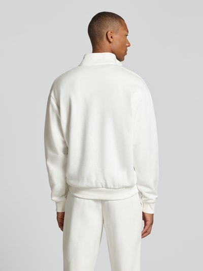Männermodel trägt weißen Regular Fit Troyer aus Baumwoll-Mix von Lacoste, glatte Textur, Ganzkörperansicht Rückansicht. Herren Troyer von Lacoste