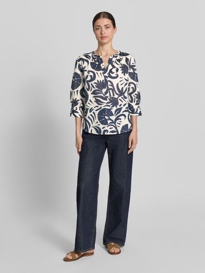 Kobiece modelka nosi Bluse mit Tunikakragen und 3/4-Arm od Oui, biała z granatowym wzorem, czysta bawełna, prosty krój, tunikowy kołnierz, zaokrąglony dół, długość tyłu w rozmiarze 36: 60 cm, długość rękawa w rozmiarze 36: 42 cm, widok całej sylwetki z przodu.