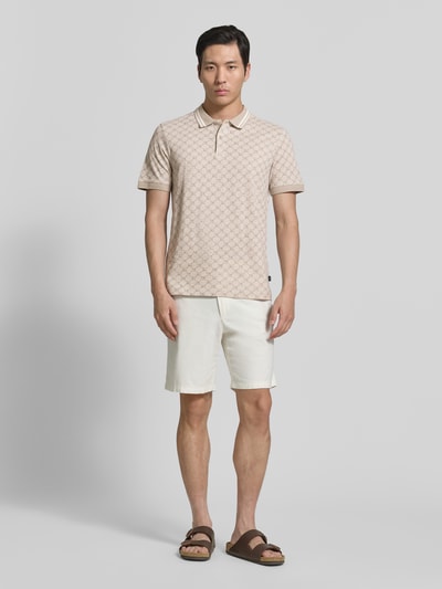 Männermodel trägt Regular Fit Poloshirt mit Logo-Muster Modell 'Jessino' von JOOP! Collection aus reiner Baumwolle, Ganzkörperansicht von vorne.