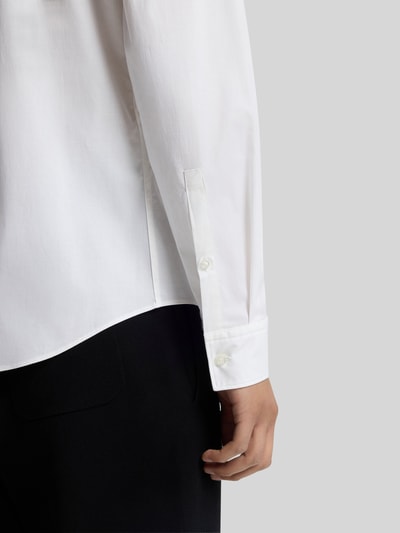 Männermodel trägt Slim Fit Freizeithemd aus Baumwoll-Mix Modell 'ERMO' von HUGO, weiß, strukturierte Oberfläche, Nahaufnahme Unterarm.