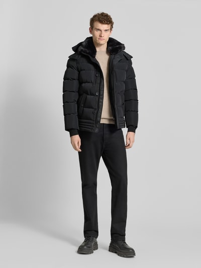 Männermodel trägt schwarze Jacke mit Sorona® Aura Filling von NAUTGÅRD, gerade geschnitten, wasserabweisend, Ganzkörperansicht von vorne.