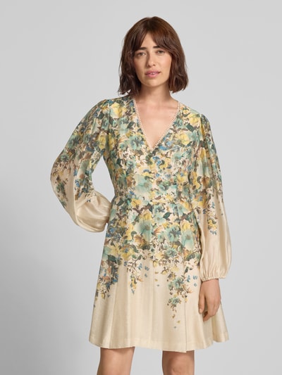 Frauenmodel trägt Cocktailkleid mit V-Ausschnitt und Häkelspitze von Vera Mont, florales Muster in Beige und Grün, Lyocell-Mix, A-Linie, Minikleid, Ganzkörperansicht von vorne.