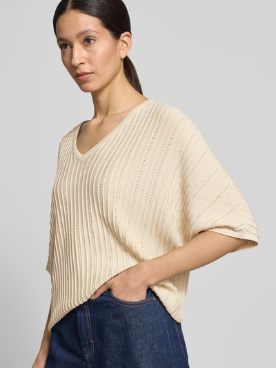 Frauenmodel trägt Strickshirt mit V-Ausschnitt Modell 'MOBBE' von B.Young, Viskose-Baumwoll-Mix, Relaxed-Fit, beige, strukturierte Oberfläche, Nahaufnahme Oberkörper.