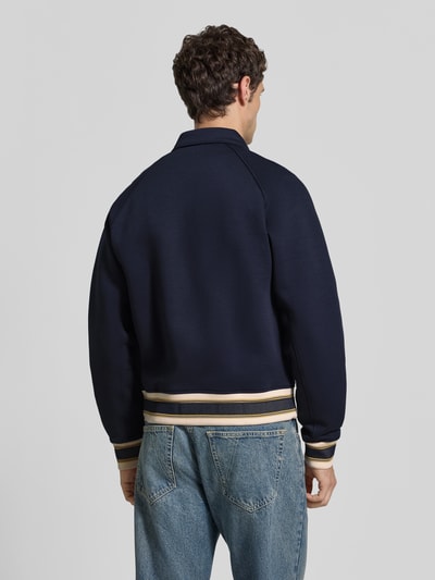 Männermodel trägt dunkelblaue Regular Fit Sweatjacke aus Baumwoll-Mix von Lacoste mit Kontrastbündchen, Herren Sweatjacke, Ganzkörperansicht Rückansicht.