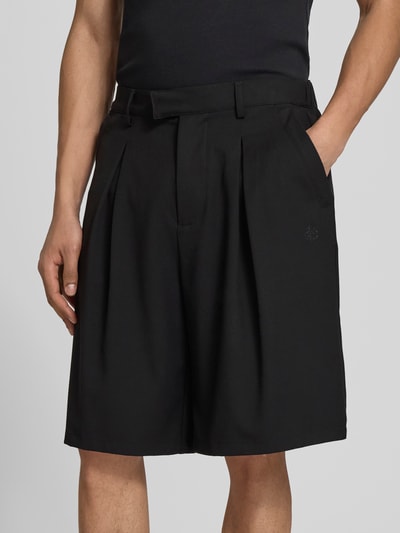 Männermodel trägt schwarze Shorts mit Viskose-Anteil von Don’t Waste Culture, Relaxed Fit, teilelastischer Bund, Nahaufnahme Oberkörper.