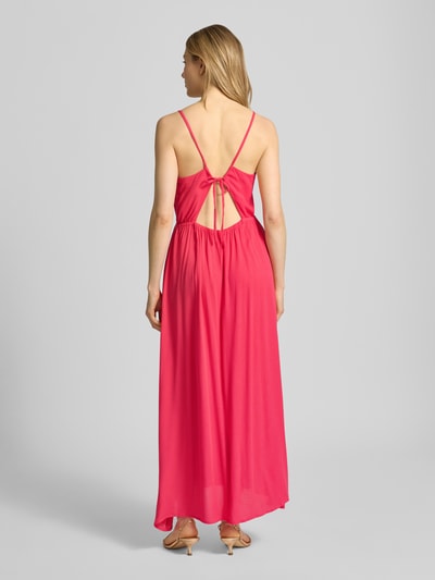 Frauenmodel trägt Midikleid aus Viskose mit tiefem Rückenausschnitt von ICHI, Taillierter Schnitt, Spaghettiträger, Modell 'MARRAKECH', leuchtendes Pink, fließende Textur, Ganzkörperansicht Rückansicht.
