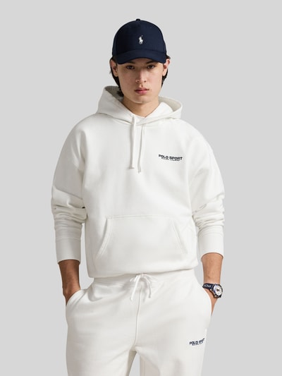 Männermodel trägt Relaxed Fit Hoodie aus Baumwoll-Mix von Polo Ralph Lauren in Unifarben Weiß mit Label-Schriftzug, Ganzkörperansicht von vorne.