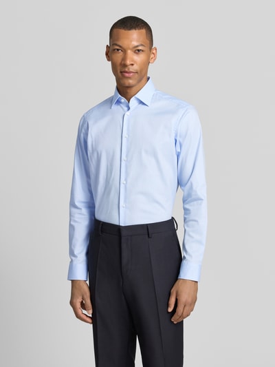 Männermodel trägt Regular Fit Business-Hemd mit Kentkragen von Christian Berg Men in Hellblau, Reine Baumwolle, Ganzkörperansicht von vorne. Rückenlänge 78 cm, Schulterbreite 43 cm, Ärmellänge 65 cm, Knopfleiste, Sportmanschetten, abgerundeter Saum.