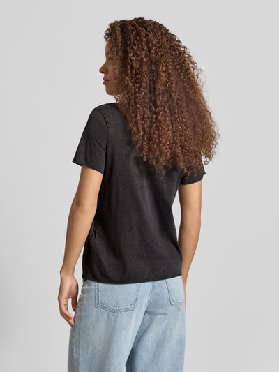 Frauenmodel trägt Regular Fit T-Shirt aus reiner Baumwolle Modell 'LISA LIFE LUCY' von Only in Schwarz auf hellgrauem Hintergrund, Ganzkörperansicht Rückansicht.