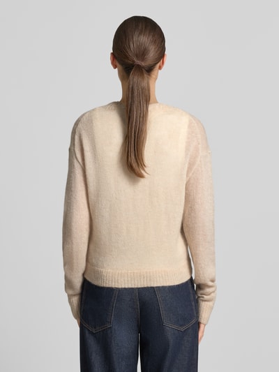 Frauenmodel trägt Strickjacke mit Woll-Anteil von COMMA in Beige mit gerippten Abschlüssen, taillierte Passform, Ganzkörperansicht Rückansicht.