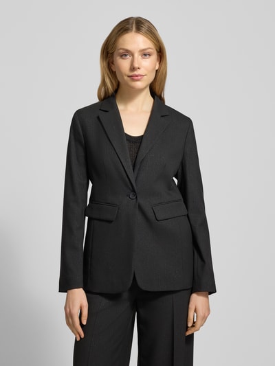 Modelka kobieca nosi Slim Fit Blazer mit Reverskragen od More & More, czarny materiał z domieszką wiskozy, kieszenie z patkami, widok z przodu, ujęcie całej sylwetki.