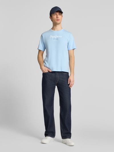 Männermodel trägt Herren T-Shirt von Pepe Jeans Modell 'EGGO' in Optik: Unifarben, Regular-Fit, Label-Print, Rundhals, Kurzarm, Jersey aus reiner Baumwolle, Ganzkörperansicht von vorne.