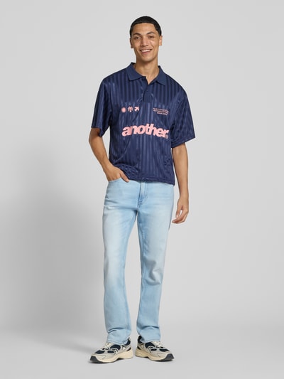 Männermodel trägt Slim Fit Jeans aus Baumwoll-Mix von Calvin Klein Jeans in Hellblau, glatte Struktur, Ganzkörperansicht von vorne.