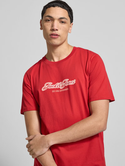 Männermodel trägt Regular Fit T-Shirt mit Logo-Print von JACK & JONES aus reiner Baumwolle, Rundhalsausschnitt, Ganzkörperansicht von vorne.
