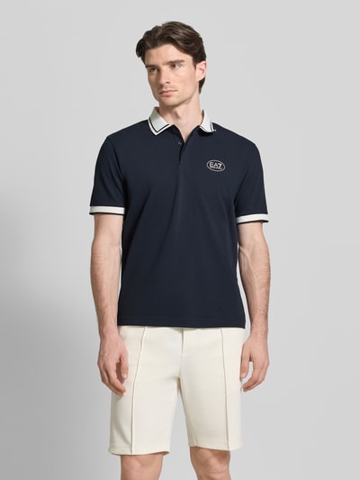 Männermodel trägt Regular Fit poloshirt mit logoprint von EA7 Emporio Armani aus katoenmix, polokraag, met korte mouwen, ruglengte maat M 68 cm. Ganzkörperansicht von vorne