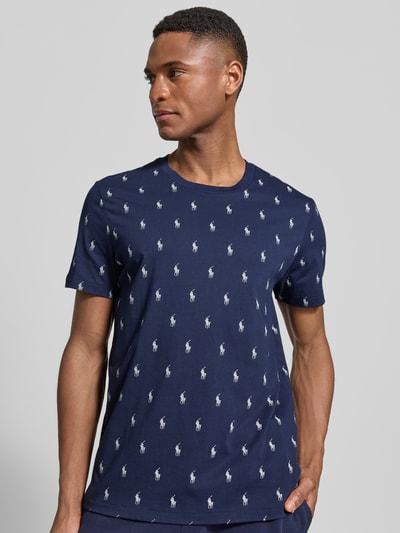 Männermodel trägt Regular Fit Pyjama-Oberteil aus reiner Baumwolle Modell 'CREW-SLEEP-TOP' von Polo Ralph Lauren Underwear in Dunkelblau mit weißem Polo-Pony-Muster und kurzem Arm, Nahaufnahme Oberkörper.