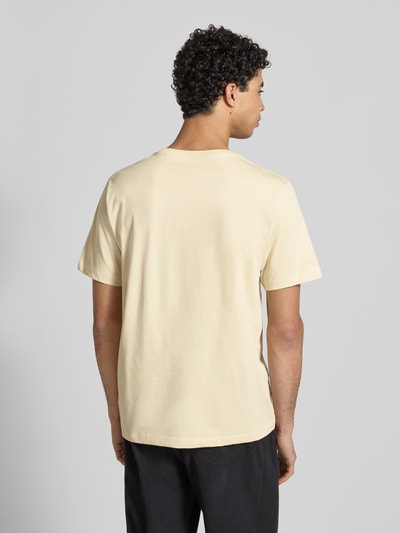 Männermodel trägt Regular Fit T-Shirt aus Baumwoll-Mix Modell 'EVOLUTION' von The North Face in Beige, Rückenansicht Ganzkörperansicht. Herren T-Shirt mit Rundhalsausschnitt, Label-Detail, Rückenlänge bei Größe M 71 cm.