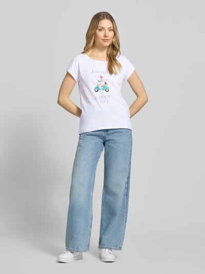 Frauenmodel trägt T-Shirt aus reiner Baumwolle von Christian Berg Woman in Weiß mit Print, gerader Schnitt, Rundhalsausschnitt, Rollsaum, Ganzkörperansicht von vorne.
