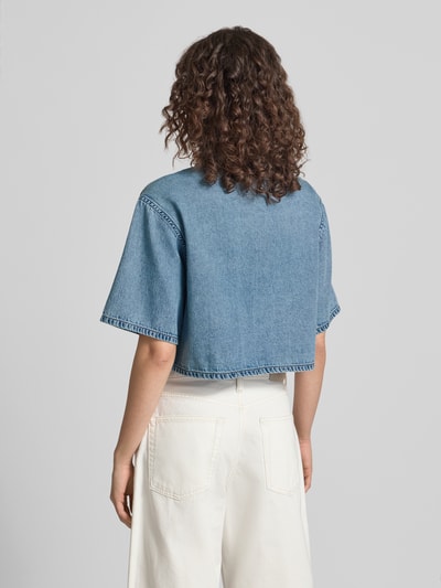 Frauenmodel trägt Cropped Hemdbluse in Denim-Optik von Calvin Klein Jeans aus reiner Baumwolle, kurzärmelig, Rückenansicht Ganzkörperansicht.
