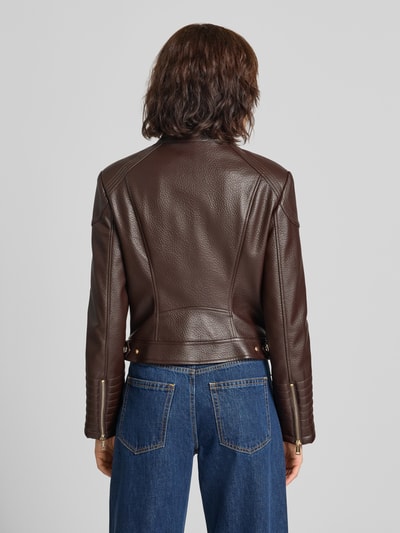 Frauenmodel trägt Bikerjacke in Leder-Optik Modell 'MARLENE CARIBOU' von GUESS in Dunkelbraun, strukturierte Oberfläche, Ganzkörperansicht Rückansicht. Damenjacke Slim Fit mit Stehkragen, Reißverschluss, Reißverschlusstaschen, Rückenlänge 49 cm, Schulterbreite 40 cm, Brustweite 45 cm, Ärmellänge 62 cm.