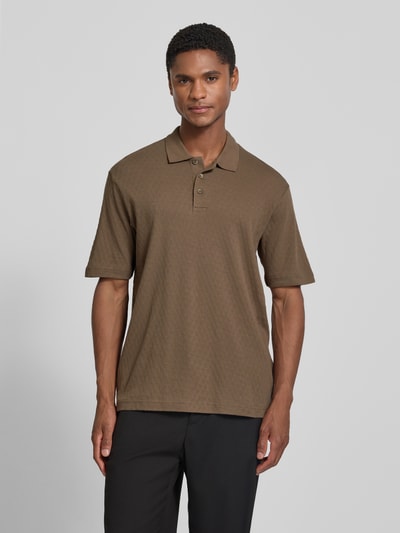 Männermodel trägt Regular Fit Poloshirt mit Knopfleiste von JACK & JONES Premium, Strukturmuster, Modell 'ROBERT', Label-Detail, Rückenlänge 75 cm bei Größe M, Farbton braun, Kurzarm, glatte Textur, Ganzkörperansicht von vorne.