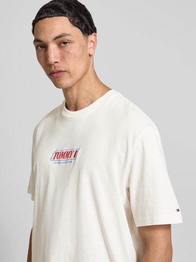 Männermodel trägt Regular Fit T-Shirt aus reiner Baumwolle von Tommy Jeans, unifarben, Label-Schriftzug, Jersey, Nahaufnahme Oberkörper.