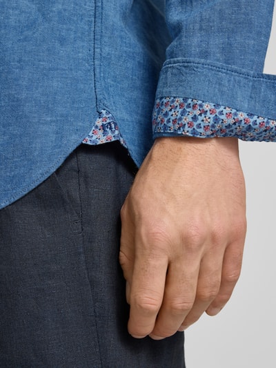 Männermodel trägt Regular Fit Business-Hemd aus Leinen-Baumwoll-Mix Modell 'ROMA' von FIL NOIR, blaue Stoffstruktur, Nahaufnahme Hand und Manschette. Rückenlänge 74 cm, Schulterbreite 41 cm, Ärmellänge 65 cm.