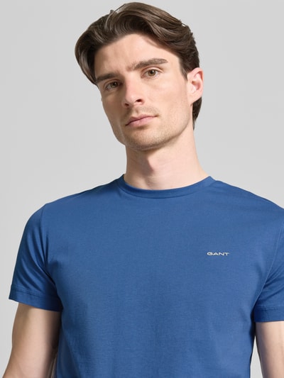 Männermodel trägt T-Shirt mit Label-Detail von Gant in Blau, reine Baumwolle, gerader Schnitt, Rundhalsausschnitt, Nahaufnahme Oberkörper.