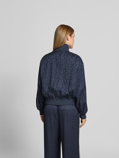 Frauenmodel trägt Tracksuit-Jacke aus Viskose-Mix von Lala Berlin in Dunkelblau mit Allover-Animal-Print, Ganzkörperansicht Rückansicht.
