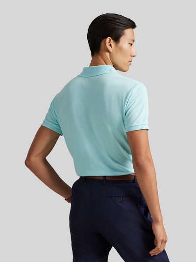 Männermodel trägt Regular Fit Poloshirt aus reiner Baumwolle von Polo Ralph Lauren in Hellblau, unifarbenes Piqué, Kurzarm, Ganzkörperansicht Rückansicht.
