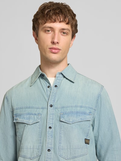 Männermodel trägt Regular Fit Freizeithemd mit Brusttaschen Modell 'dakota' von G-Star Raw in hellem Blau, Material-Mix mit Baumwoll-Anteil, Nahaufnahme Oberkörper.