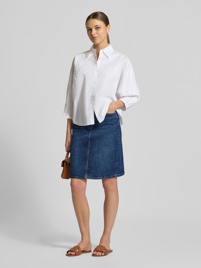 Modelka nosi Regular Fit Rock in Denim-Optik von Christian Berg Woman, mieszanka bawełny, długość do kolan, 5 kieszeni, zapięcie na guzik i zamek, szerokość w rozmiarze 36: 39 cm, całkowita długość: 57 cm, imitacja denimu, widok całej sylwetki z przodu.