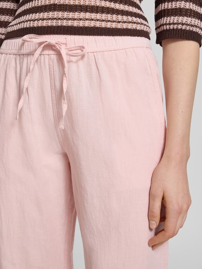 Frauenmodel trägt Stoffhose mit Leinen-Anteil und Eingrifftaschen von Neo Noir in Hellrosa, französische Eingrifftaschen, Nahaufnahme Oberkörper, Leinen-Baumwoll-Mix, elastischer Bund, Modell Sonar, Damen, ausgestellter Schnitt