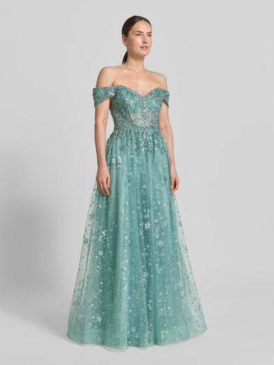 Modelka nosi Corsagenkleid mit Stitchings und Pailletten od Unique, zielony tiul, krój A-linii, maxi, transparentne wstawki z cekinami, długość tyłu w rozmiarze 36: 160 cm, szerokość w rozmiarze 36: 37 cm, widok całej sylwetki z przodu.
