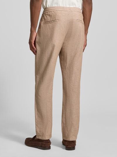 Männermodel trägt Hose mit Leinen-Anteil und französischen Eingrifftaschen von Scotch & Soda, beigefarbener Baumwoll-Mix, elastischer Bund, Ganzkörperansicht Rückansicht.