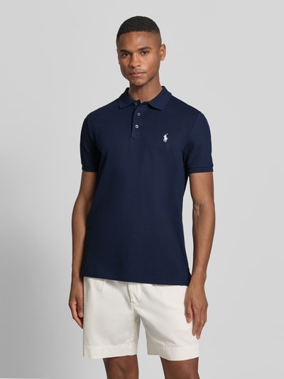 Männermodel trägt Slim Fit Poloshirt aus Baumwoll-Mix von Polo Ralph Lauren, Optik: Unifarben, Piqué-Struktur, Logo-Detail, Ganzkörperansicht von vorne.