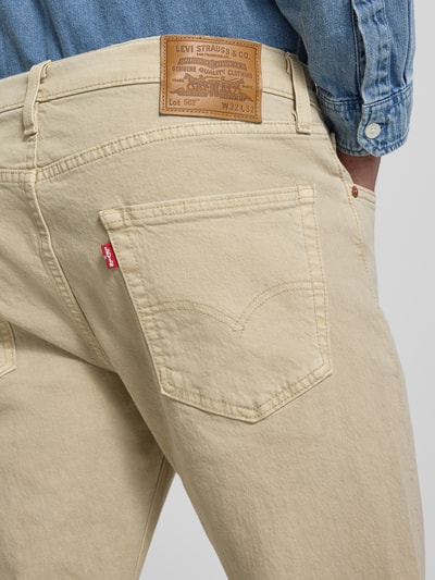 Mężczyzna nosi jeansy o kroju tapered fit z bawełnianego miksu Tapered Fit Jeans aus Baumwoll-Mix Modell '502™ TAPER' od Levi's®, widok z tyłu, zbliżenie na biodra i kieszeń, Herren Tapered Fit Jeans von Levi's®.