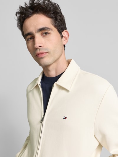 Männermodel trägt Regular Fit Sweatjacke aus reiner Baumwolle von Tommy Hilfiger, Optik: Unifarben, Nahaufnahme Oberkörper.