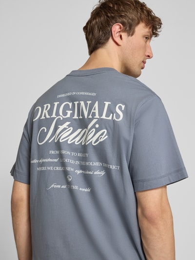 Mannenmodel draagt T-shirt met statementprint model 'NORREBRO' van Jack & Jones, puur katoen, recht model, ronde hals, ruglengte bij maat M 68 cm, detailopname rugaanzicht.