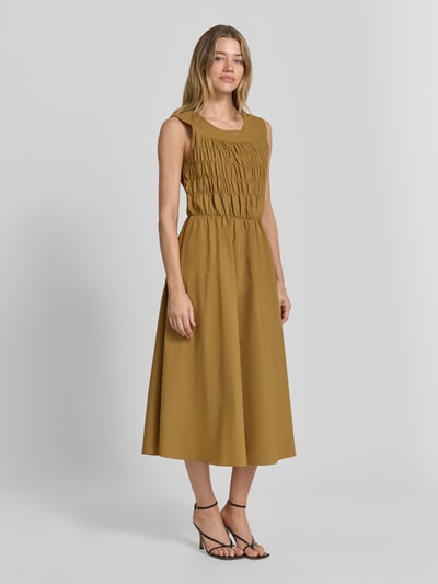 Frauenmodel trägt Midikleid mit V-Ausschnitt Modell 'NETTI' von Soyaconcept aus Material-Mix, gerader Schnitt, braune Farbe, Ganzkörperansicht von vorne, Rückenlänge bei Größe S 124 cm, Brustweite 43 cm.