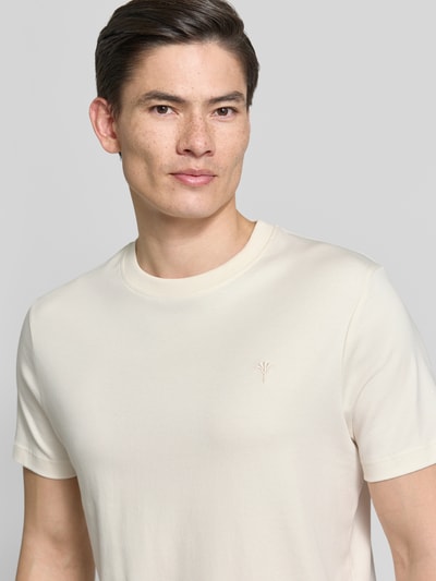 Männermodel trägt T-Shirt mit Logo-Stitching Modell 'Priamo' von JOOP! Collection aus Reiner Baumwolle, Rundhalsausschnitt, Nahaufnahme Oberkörper.