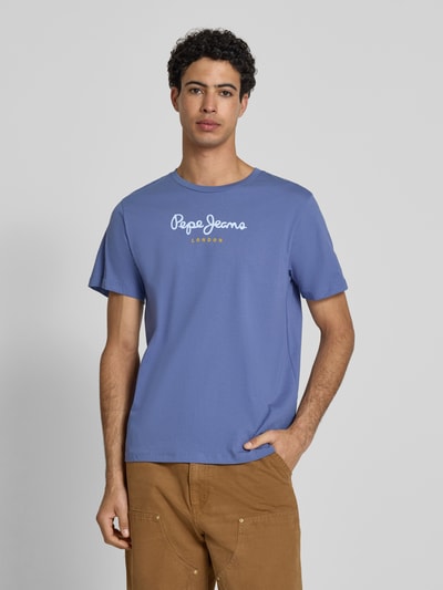 Męski model nosi Regular Fit T-Shirt aus reiner Baumwolle Modell 'EGGO' von Pepe Jeans, jednokolorowy, nadruk z logo, okrągły dekolt, krótki rękaw, materiał dżersej, czysta bawełna. Ganzkörperansicht von vorne.