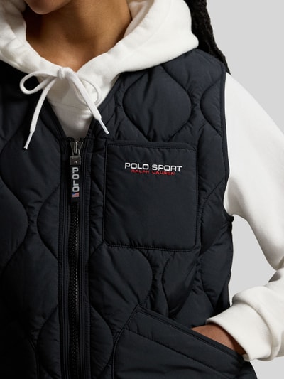 Vrouwenmodel draagt Regular Fit Steppweste met borstzak van Polo Ralph Lauren in effen zwart, label stitching, detailweergave bovenlichaam.