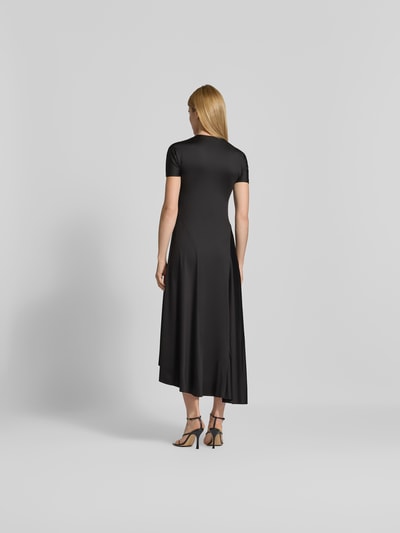 Frauenmodel trägt Midikleid mit verlängerter Rückseite von Victoria Beckham in Schwarz, elastischer Material-Mix, Ganzkörperansicht Rückansicht.