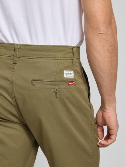 Mannenmodel draagt Straight Fit Chinos aus Baumwoll-Mix van Levi’s®, olijfgroen, katoenmix met steek- en achterzak, detailopname rug.