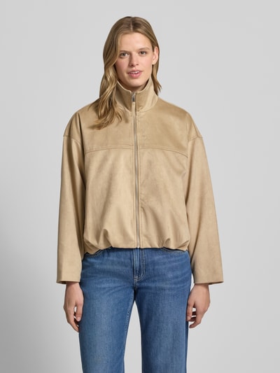 Frauenmodel trägt Jacke in Leder-Optik mit Reißverschluss und Eingrifftaschen von Gina Tricot im Material-Mix mit Stretch-Anteil, Relaxed-Fit, in Beige mit glatter Textur, Ganzkörperansicht von vorne.