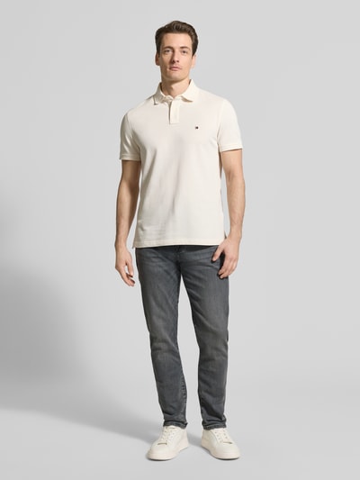 Männermodel trägt Slim Fit Jeans aus Baumwoll-Mix Modell 'BLEECKER' von Tommy Hilfiger in Denim-Optik mit Label-Patch, 5-Pocket-Design, Ganzkörperansicht von vorne.