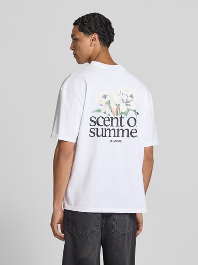 Männermodel trägt oversized wit T-shirt van puur katoen met labelprint, model 'Miles' van Pegador, ruglengte maat M 70 cm, Ganzkörperansicht Rückansicht.