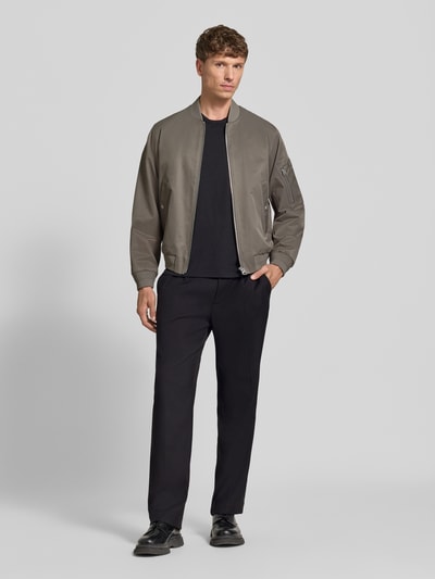 Männermodel trägt Regular Fit College-Jacke mit Baumwoll-Anteil von Marc O'Polo in Uni-Optik, Reißverschluss, elastische Bündchen, Ganzkörperansicht von vorne.
