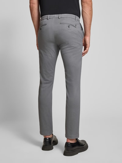 Männermodel trägt Slim Fit Chino aus Baumwoll-Mix von bugatti in Grau, Gesäßtaschen, elastisch, Ganzkörperansicht Rückansicht.
